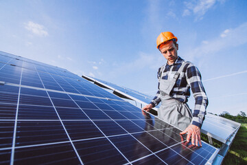 Man worker in the firld by the solar panels