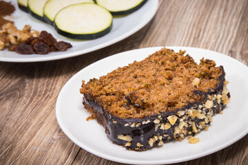 Homemade pastry made of zucchini with nuts and raisin. Wooden background
