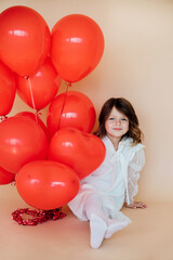 Cute little girl with heart shaped balloons on Valentine's day. family, love. gifts for the holiday.