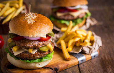 Tasty hamburgers with french fries and ketchup on wooden table