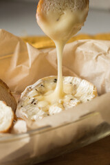 Camembert cheese baked in the oven with garlic sauce and spices. Camembert with croutons in a...