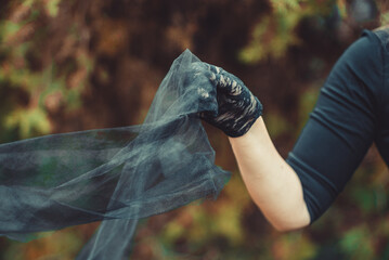 girl in mourning in black clothes and lace gloves holds a light veil 1