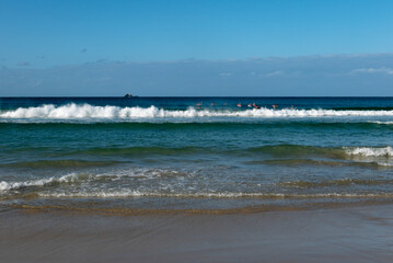 beach and waves with kids on boards
