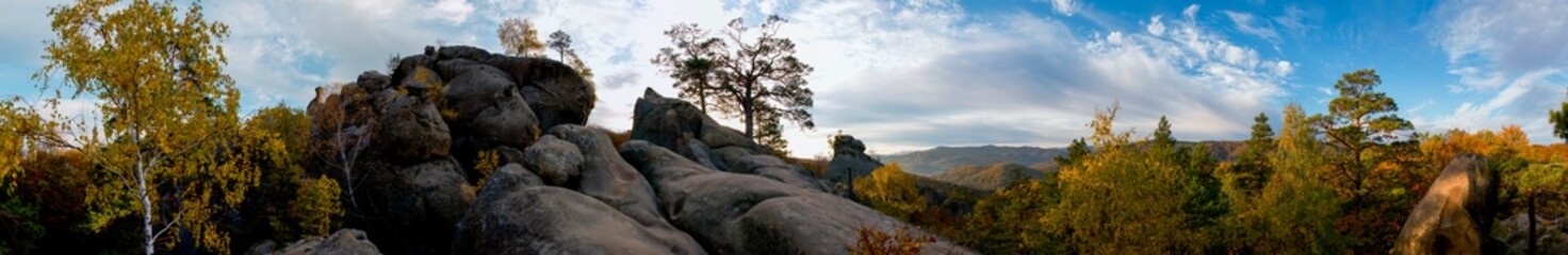 Autumn panorama in the rocky mountains. Trees in a color palette.