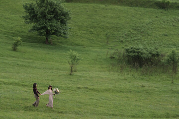 Romantic, young and happy caucasian couple in stylish clothes traveling together in the beautiful countryside nature. Love, relationships, romance, animal care, happiness concept.