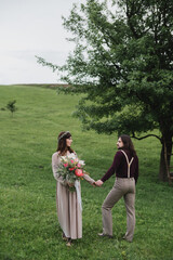 Romantic, young and happy caucasian couple in stylish clothes traveling together in the beautiful countryside nature. Love, relationships, romance, animal care, happiness concept.
