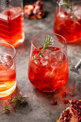 Red fruit cocktail with rosemary, dark background. Long drink in glass. Summer drinks.
