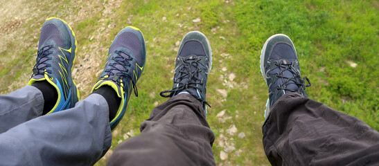 High up in the air on the cableway. View of legs hanging above the ground