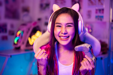 Young asian woman is using virtual reality headset. Neon light studio portrait. Concept of virtual reality, simulation, gaming and future technology.Asian woman play game in living room.