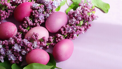 Obraz na płótnie Canvas Close-up of beautiful lilac Easter eggs with blooming lilac branches. Easter decor. Selective focus.