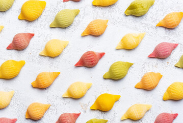 Colorful shell pasta pattern on white background.