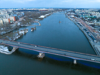 Duża rzeka widziana z drona podczas zachodu słońca, Warszawa, widoczne zabudowania i brzeg, mosty - obrazy, fototapety, plakaty