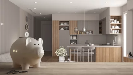 Fotobehang Wooden table top or shelf with white piggy bank with coins, modern bright kitchen with dining table, expensive home interior design, renovation restructuring concept architecture © ArchiVIZ