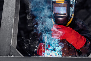 Factory industry worker welder in protective uniform with mask on workplace metalwork