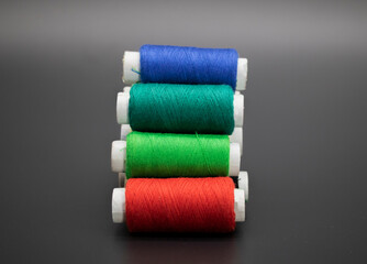 Group of whole haberdashery item colorful thread spools isolated on black background. Coloured threads.