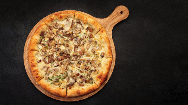 Pizza with mushrooms and cheese, on a wooden board