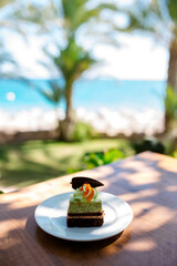 Portuguese marzipan made fruit patterns. One colorful traditional Portuguese almond marzipan cakes. Top view on beautiful beach and ocean background.