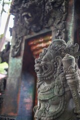 Traditional ancient stone statue at bali temple background in indonesia