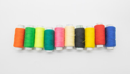 group of colorful yarn or spool thread over on yellow background like rainbow