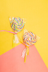 Fototapeta premium Colorful lollipop with transparent cellophane wrapping isolated on colorful background