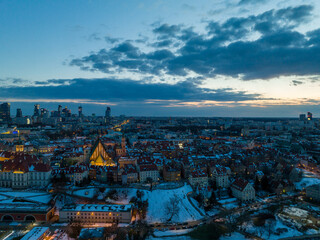 Widok na zamek królewki i stare miasto w Warszawie z drona, w tle wieżowce, zaśnieżone dachy,...