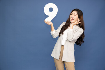Young Asian business woman showing number 9 or nine isolated on deep blue background