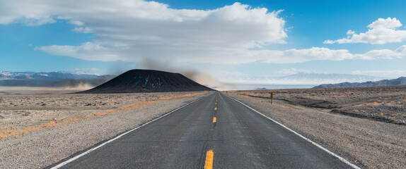 Highway disappearing into a distant dust storm over a lithium mining operation in a barren desert landscape - Silver Peak Albemarle, Nevada