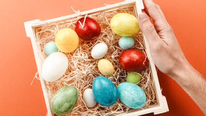 Fototapeta na wymiar hand with basket of painted easter eggs