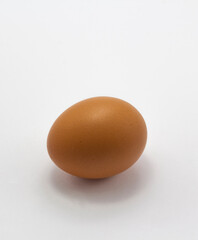 single brown egg on white background, free range egg copy space vertical