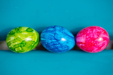 3 easter eggs on aquamarine background, happy, colorful easter,