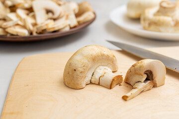 mushrooms on a wooden board. cutting champignons on a wooden board and a knife. Fresh mushrooms.