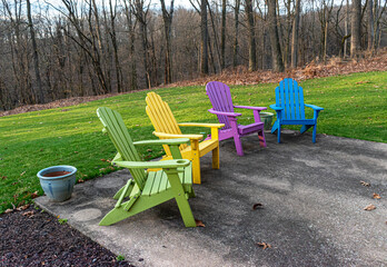 Adirondack chairs sit on a patio in early Spring in Hershey PA. Purple, Green, Yellow, and Blue...