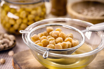 chickpeas being sieved to extract aquafaba, cooking liquid used as an alternative to egg whites