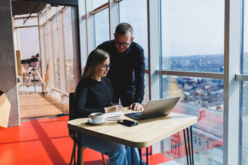 Happy business people are sitting at the table, talking, laughing, discussing business documents, smiling, colleagues are collaborating in the office at a briefing, brainstorming at a meeting