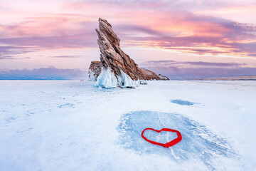 Beautiful winter landscape island Ogoy frozen lake Baikal blue ice with red hearth love sunset light