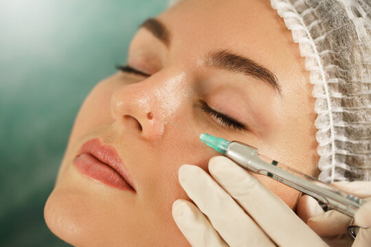 Woman getting injection of local anesthetic before mole removal treatment in a medical aesthetic clinic