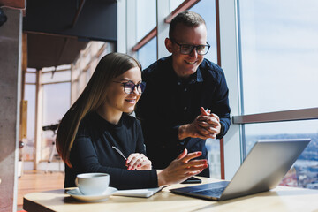 Successful business team, male and female colleagues talking at work, discussing a new project with a laptop, young executives have a friendly conversation, cooperate in teamwork in the office