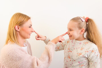Happy mother and her little daughter having fun playing together