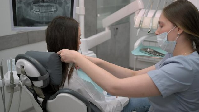Dentist at work, dentistry. Young female doctor preparing female patient for dental treatment