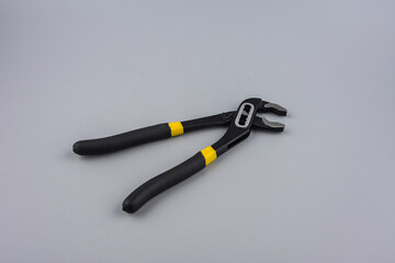 Tongue-and-groove slip-joint pliers detail with movable jaw on a white background.