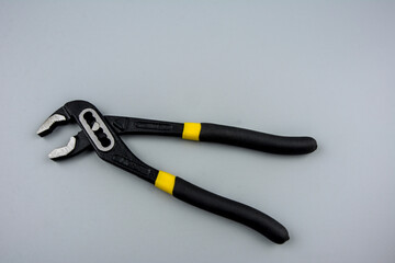 Tongue-and-groove slip-joint pliers detail with movable jaw on a white background.