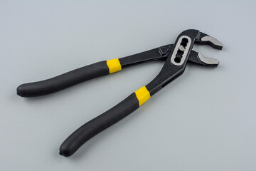 Obraz premium Tongue-and-groove slip-joint pliers detail with movable jaw on a white background.