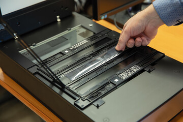 Digitization scanning of photographic film negatives on the scanner. Converting an image to digital...