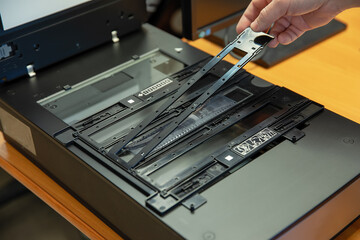 Digitization scanning of photographic film negatives on the scanner. Converting an image to digital...