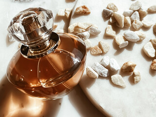 Flacon of perfume, luxury fragrance, glass bottle on marble stone background, beauty product