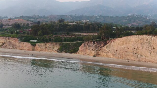 Montecito beach aerial pulling away over glassy ocean on hazy day