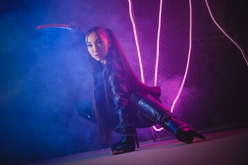 Girl warrior with katana in the smoke in the neon lights.