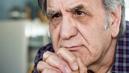 Thoughtful elderly man sitting alone at home	