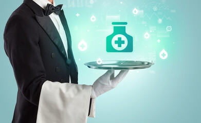 Handsome young waiter in tuxedo holding healthcare icons on tray