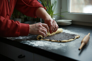 The culinary process. Bakery products. Preparation of a roll with poppy seeds. Raw dough, flour,...